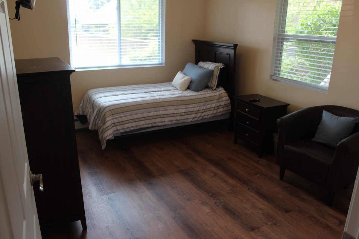A cozy bedroom with a single bed and wooden flooring.
