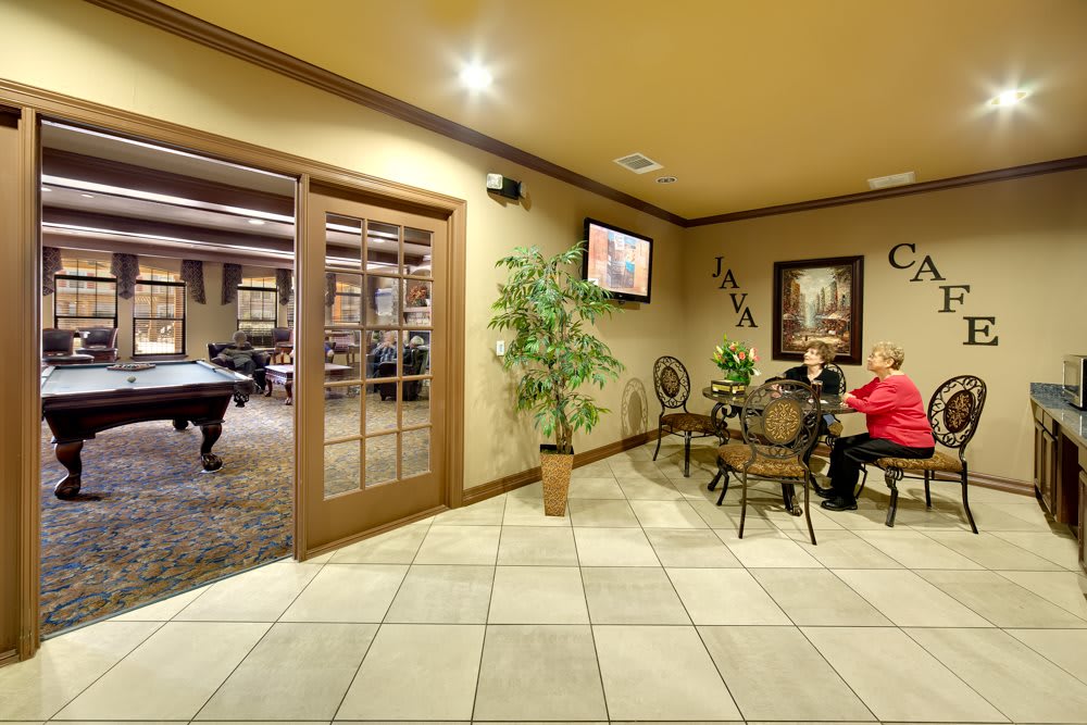 A cozy lobby area with seating, a television, and decorative plants.