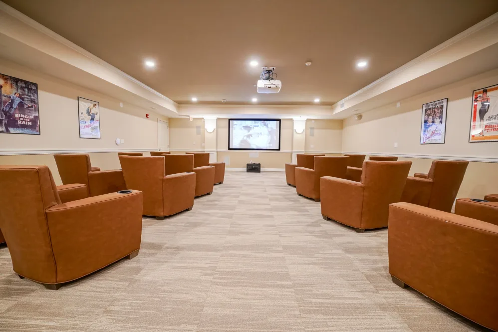 A modern theater room with plush seating and a large screen, ready for a viewing experience.