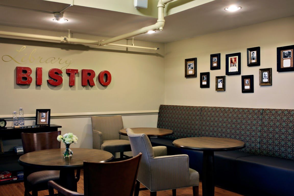 Cozy bistro interior with tables, chairs, and wall decorations.
