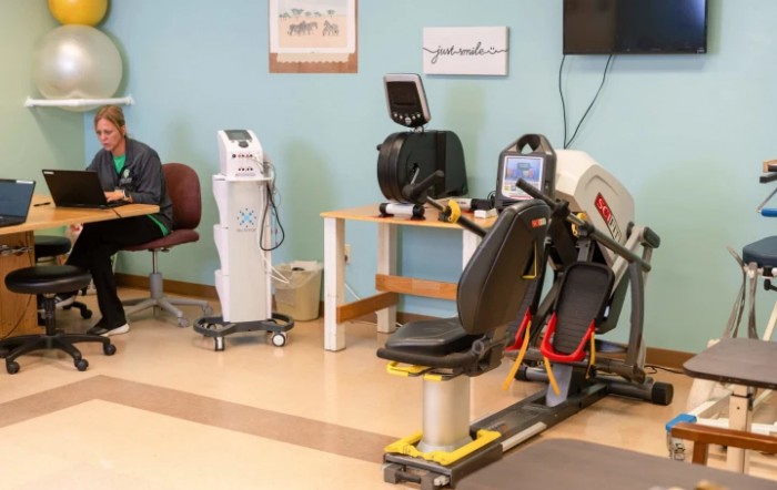 A rehabilitation room with various exercise equipment for physical therapy.