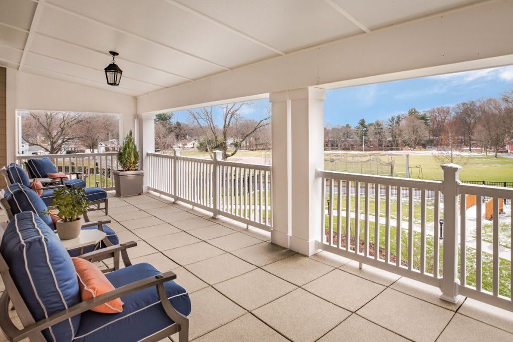 A spacious porch with comfortable seating overlooks a scenic landscape.