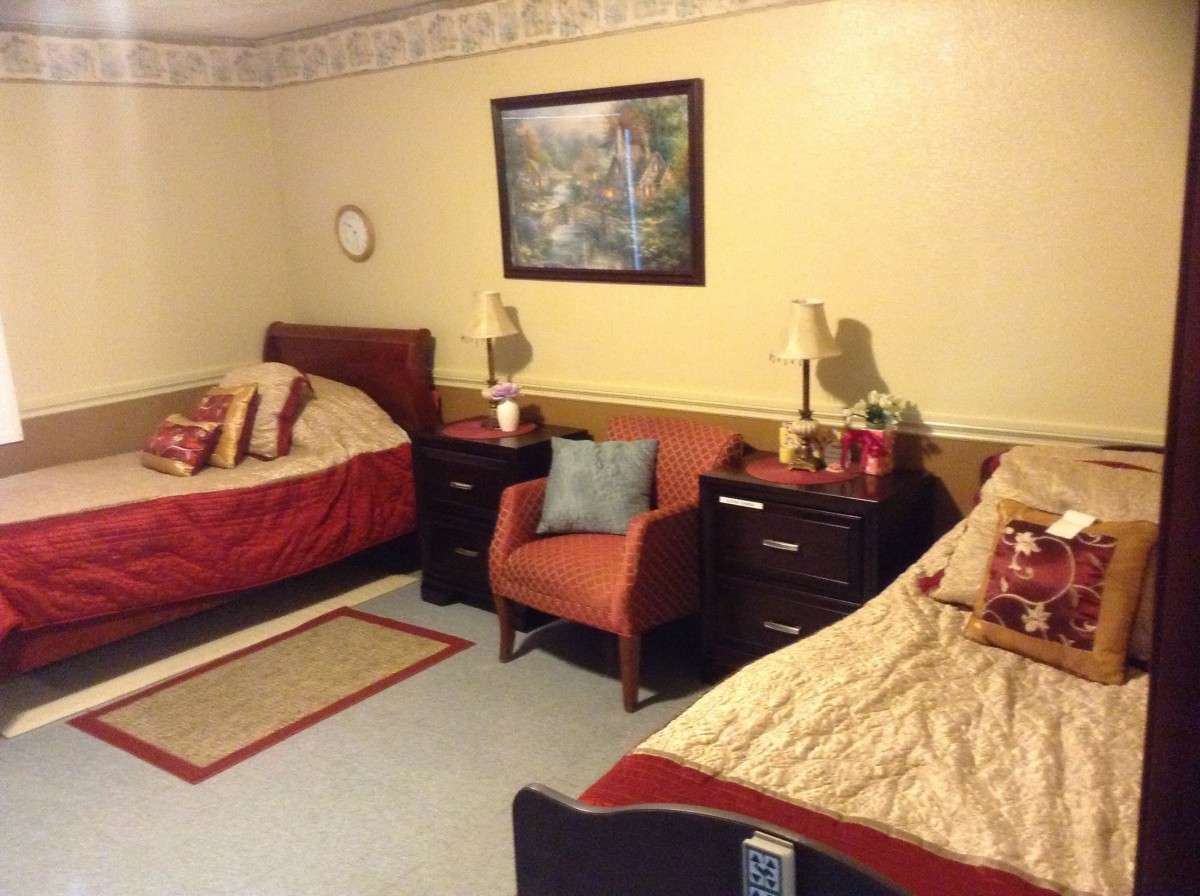 A cozy bedroom with two beds, an armchair, and decorative elements.