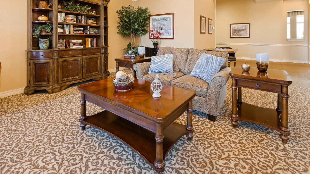 A cozy living room with a sofa, coffee table, and bookshelf.