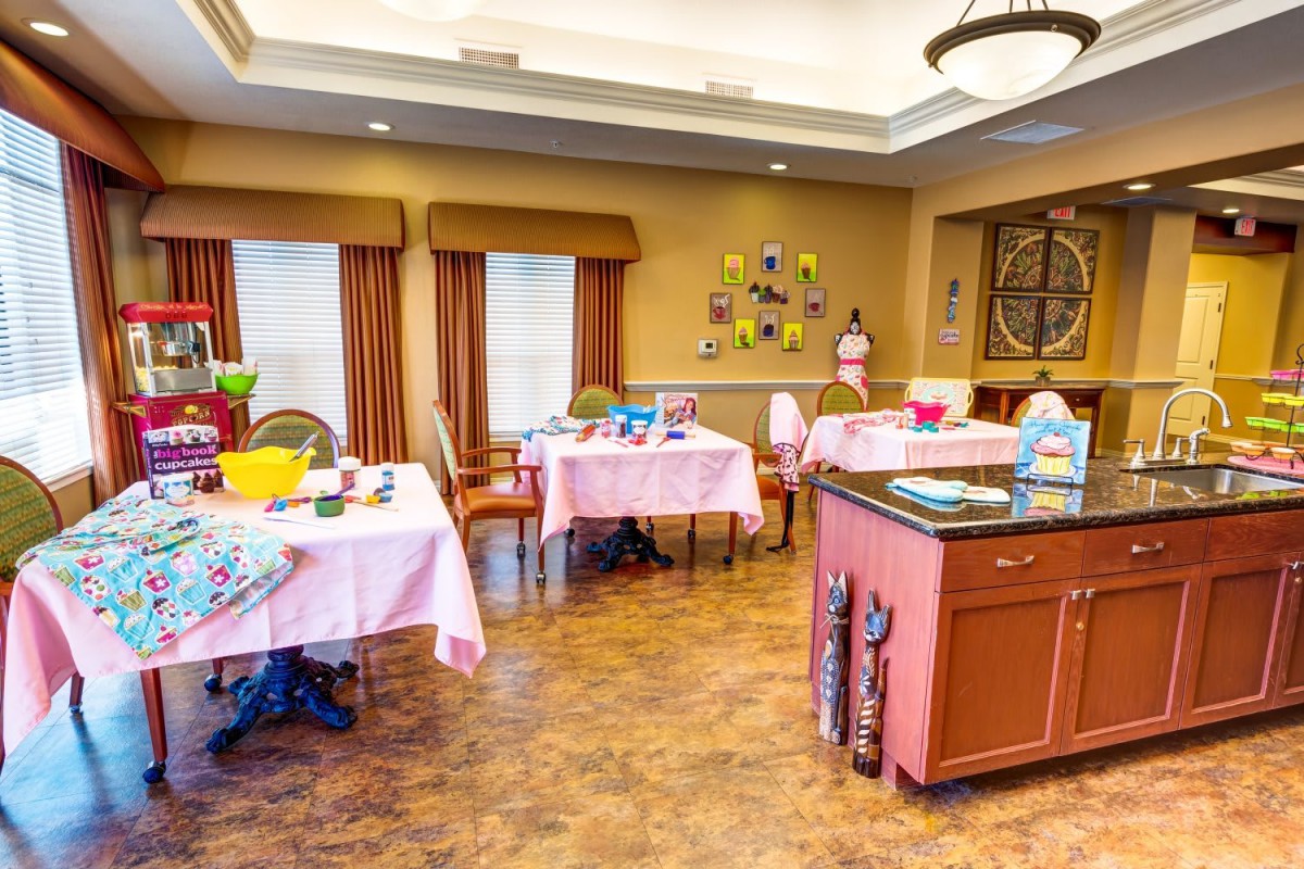 A brightly decorated room with tables and chairs set up for dining or activities.