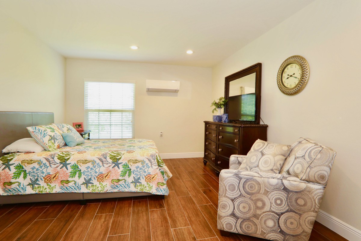 A cozy bedroom with floral bedding and wooden furniture.