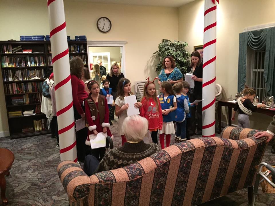 A group of children performing in a decorated room with an audience watching.