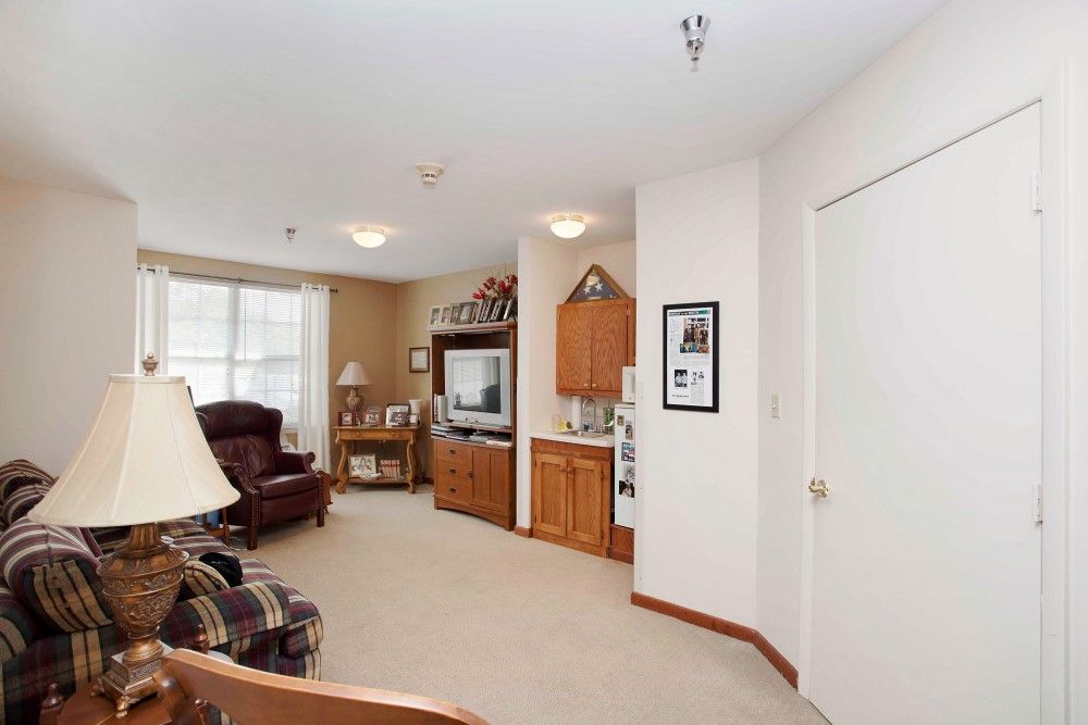 A cozy living room featuring a television, sofa, and wooden cabinet with warm lighting.