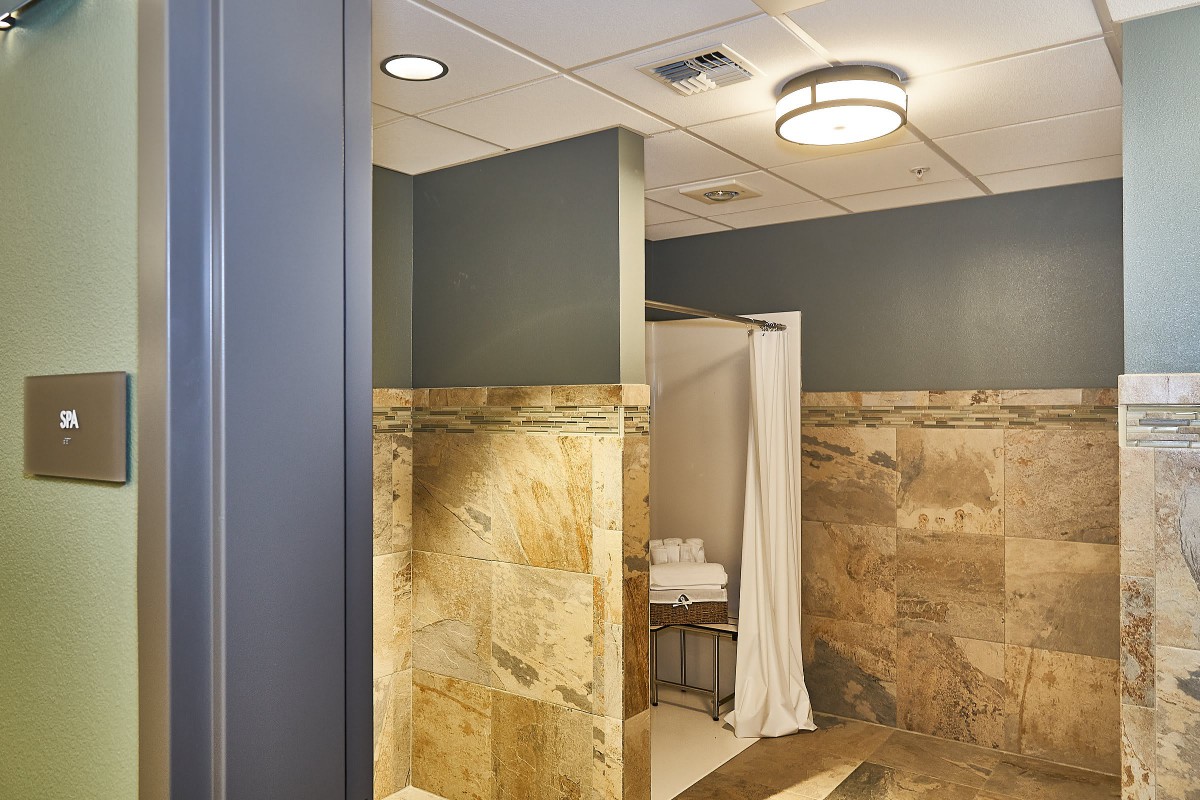 A modern bathroom featuring a tiled shower area and contemporary lighting.