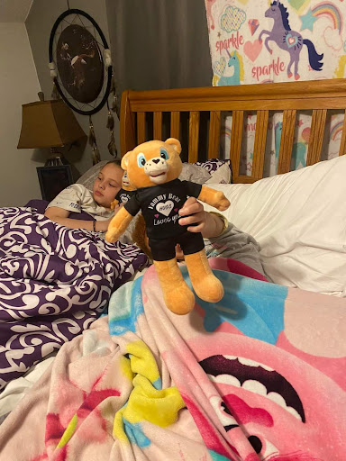 A cozy moment in bed with a cheerful stuffed bear.