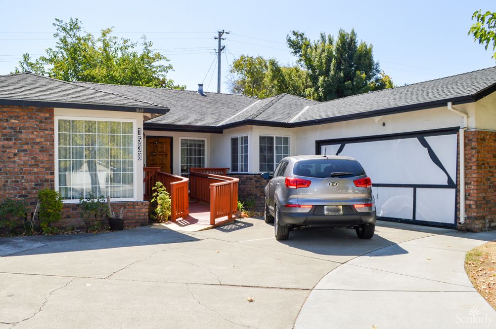 A suburban house with a car parked in the driveway.