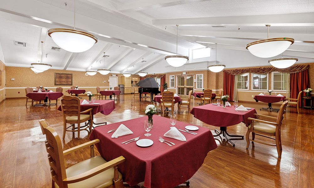 An elegant dining area with red tablecloths and arranged settings in a spacious restaurant.
