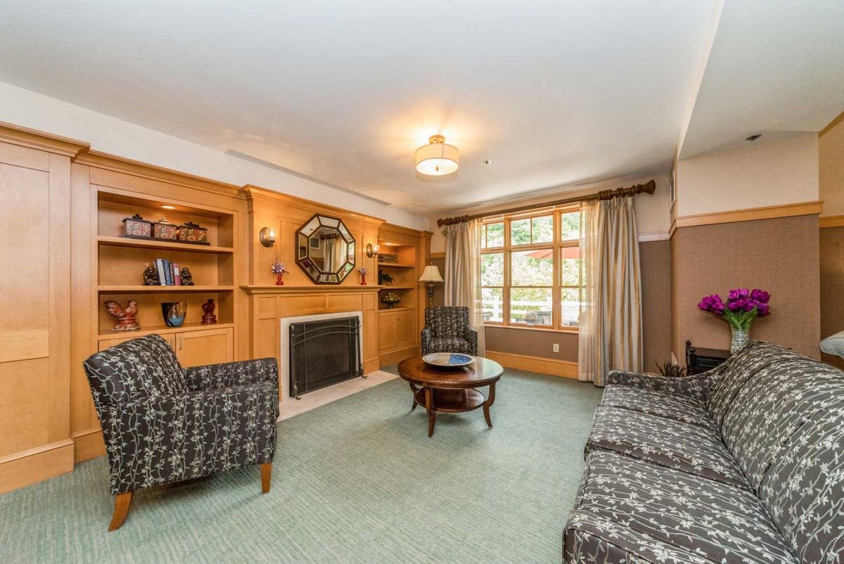 A cozy living room featuring a fireplace, built-in bookshelves, and comfortable seating.