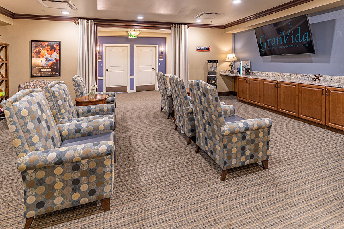 A comfortable waiting room with arranged chairs and a television on the wall.