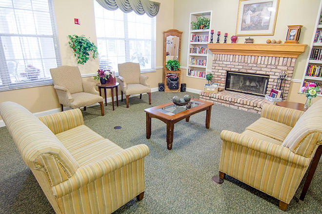 A cozy living room with comfortable seating, a fireplace, and bookshelves.