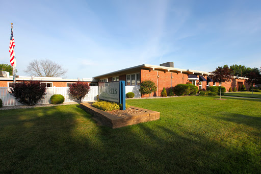 A well-maintained building surrounded by green grass and shrubbery.
