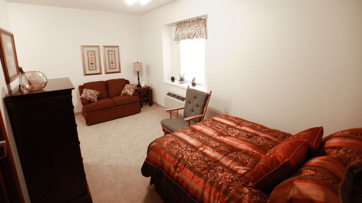 A cozy bedroom with a bed, sofa, and decorative elements.