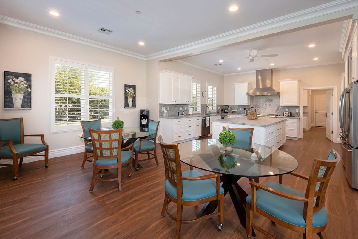 A modern kitchen and dining area with wood flooring and bright lighting.