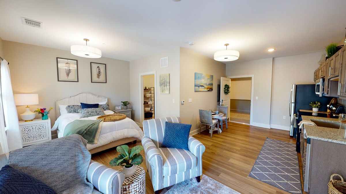 A modern living space with a combined bedroom and living area, featuring stylish furniture and decor.