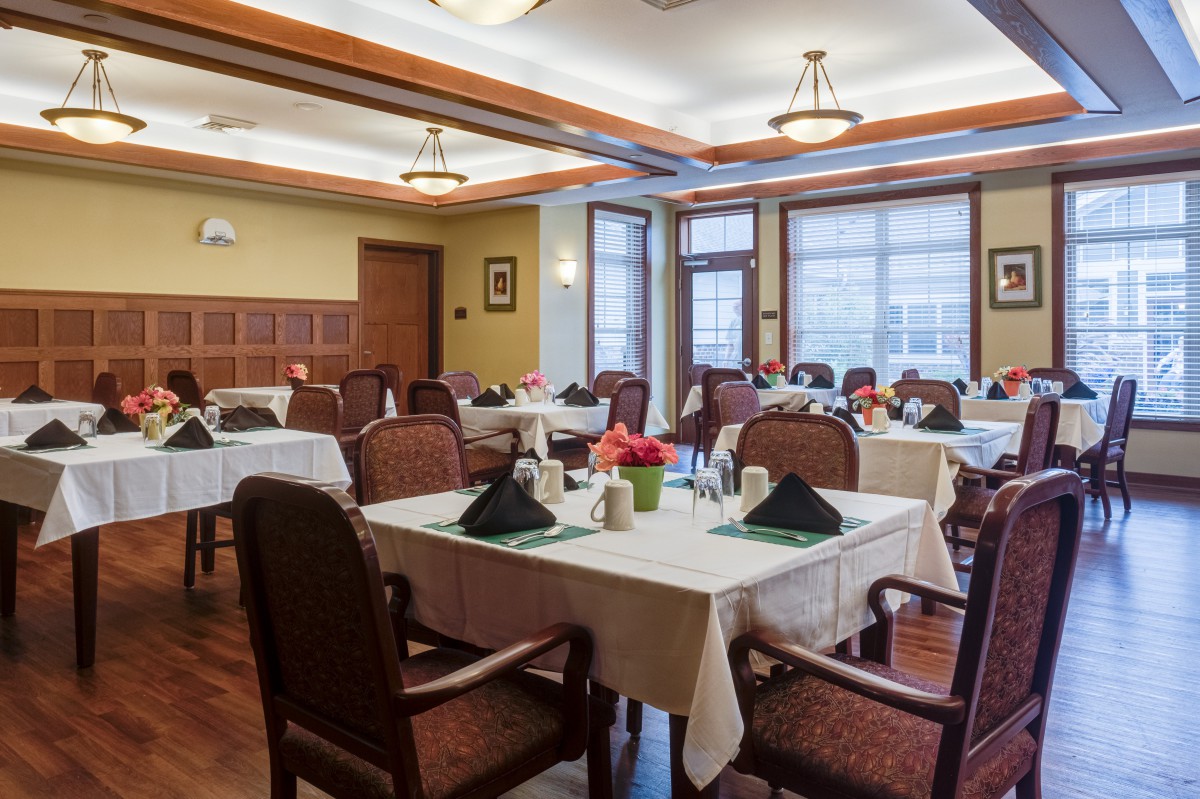 A well-decorated dining room with neatly arranged tables and chairs.