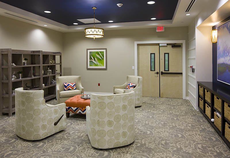 A modern waiting room featuring comfortable seating, stylish furniture, and contemporary artwork.