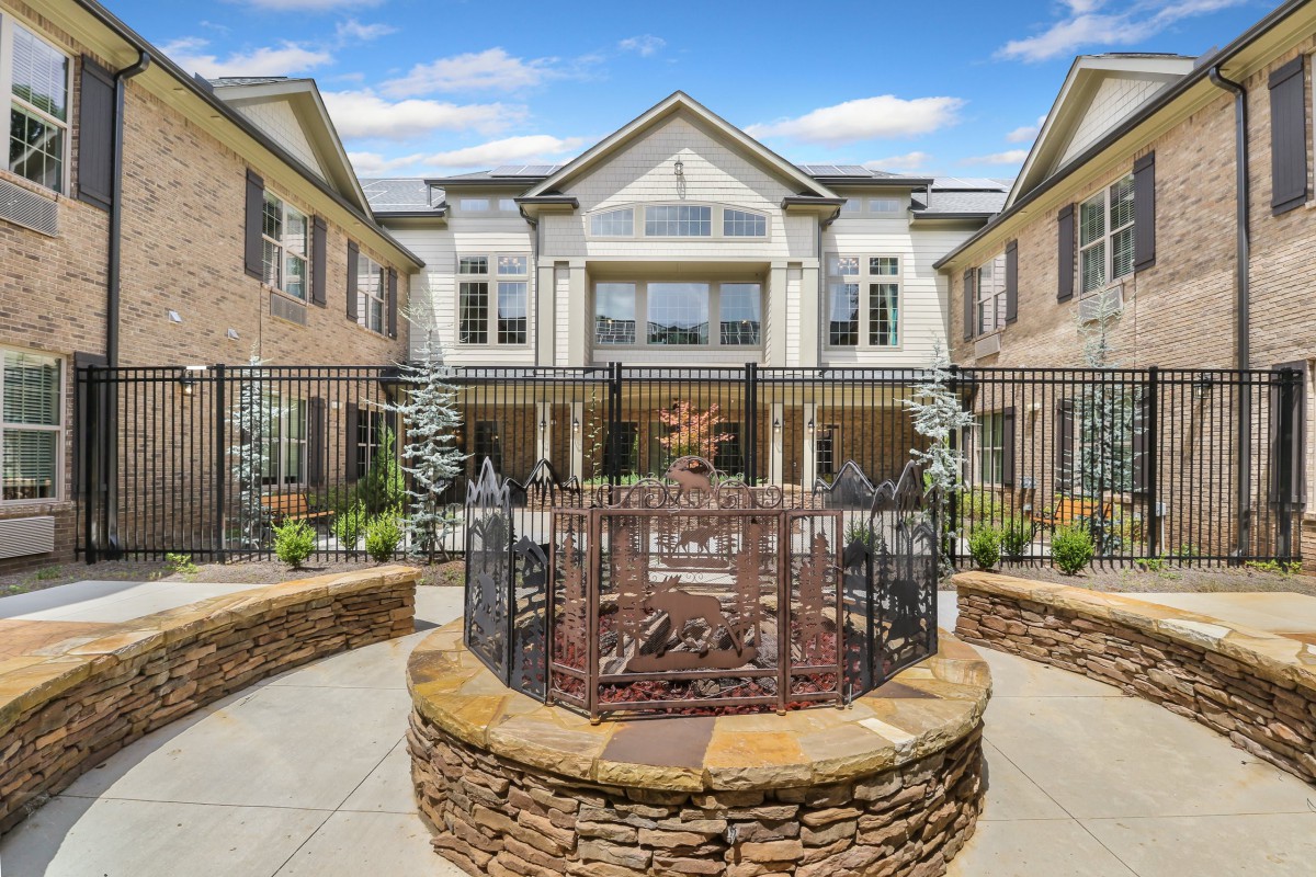 A beautifully designed building with a gated courtyard and elegant landscaping.