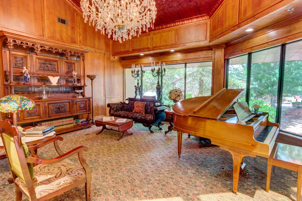 A luxurious living room featuring a grand piano and vintage decor.