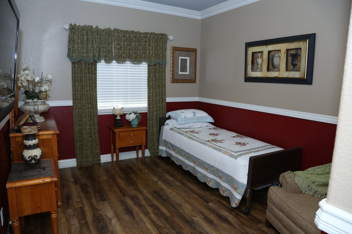 A cozy bedroom with a single bed, wooden flooring, and decorative wall art.