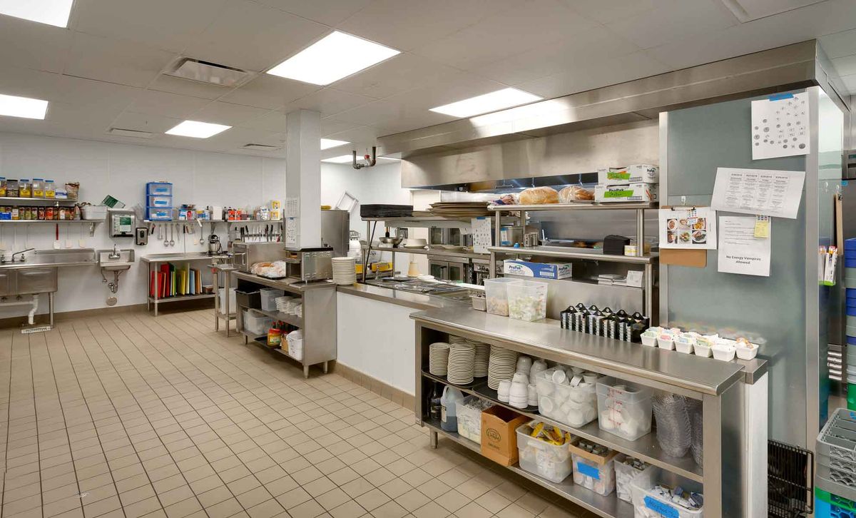 A clean and organized commercial kitchen with stainless steel surfaces and various cooking equipment.