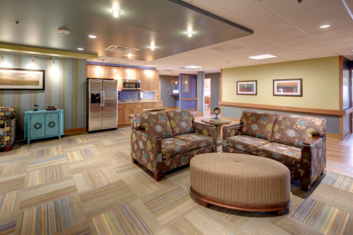 A cozy and modern lounge area featuring comfortable seating and a kitchenette.