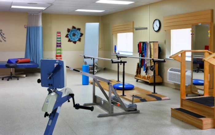 A rehabilitation room equipped with various exercise and therapy equipment.