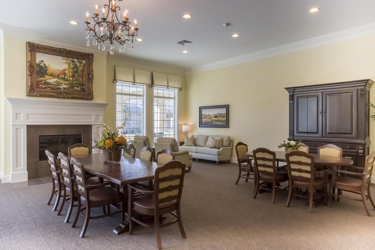 A cozy dining room with elegant furniture and a chandelier.