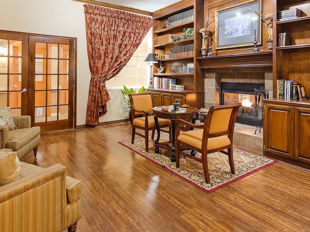 A cozy living room with a fireplace, bookshelves, and elegant furniture.