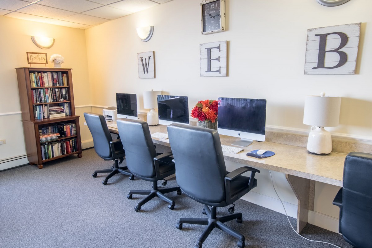 A modern office space with several computer workstations and comfortable chairs.