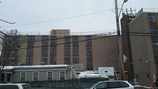 A view of a multi-story building against a cloudy sky, showcasing urban architecture and infrastructure.