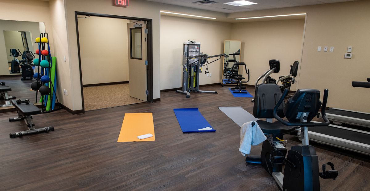 A fitness room equipped with exercise mats and workout machines.