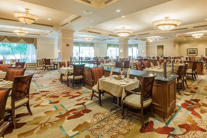 A spacious and elegantly decorated dining area with neatly arranged tables and chairs.