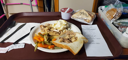 A meal consisting of chicken, mashed potatoes, mixed vegetables, a sandwich, and dessert.