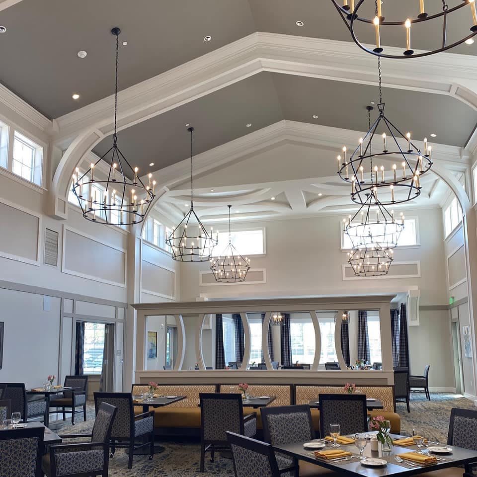 An elegant dining space with high ceilings and beautiful chandeliers.
