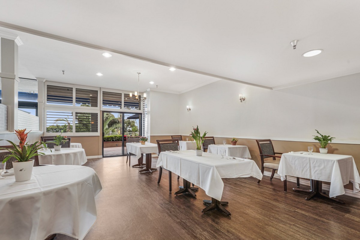A modern restaurant interior with neatly arranged tables and chairs, ready for guests.