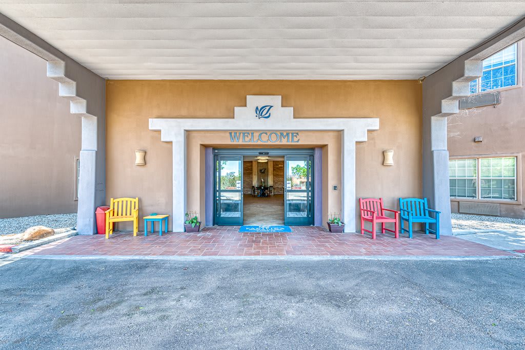 A welcoming hotel entrance with colorful chairs lining the walkway.
