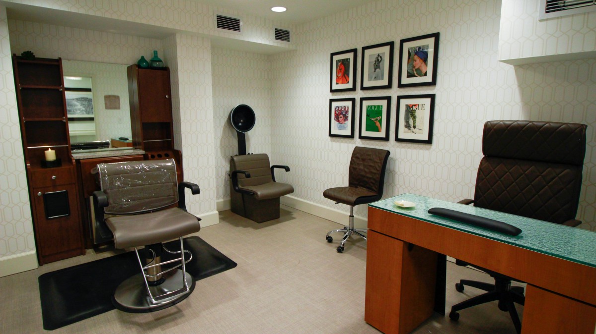 Modern hair salon interior with chairs and wall artwork.