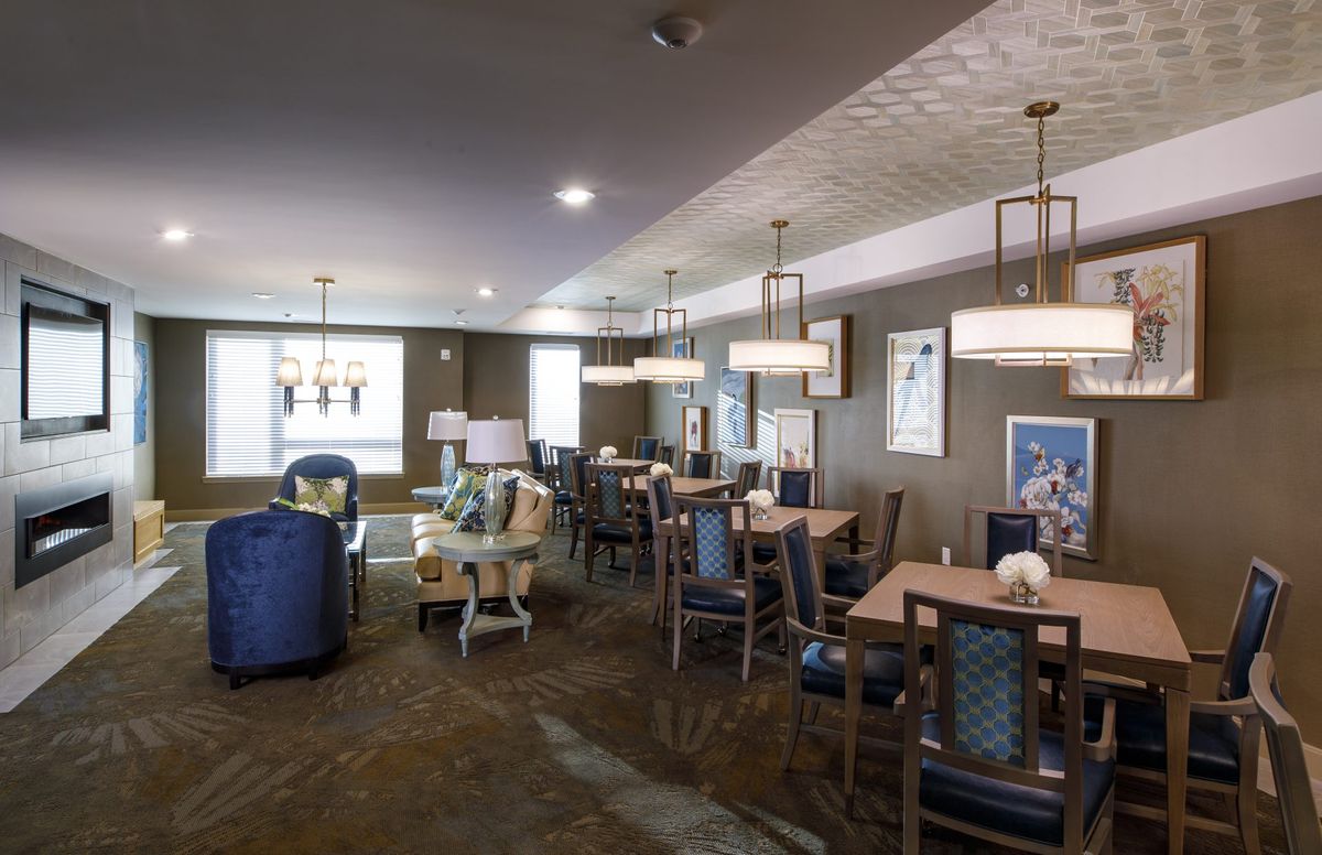 A modern dining area with tables and chairs, featuring stylish lighting fixtures.