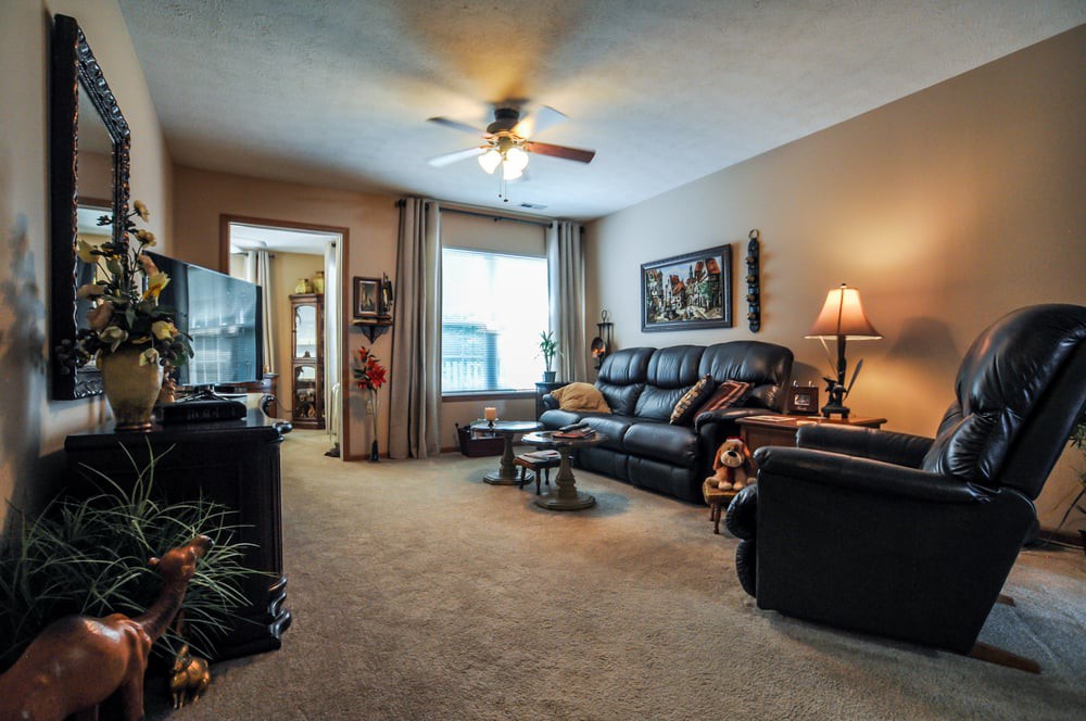 A cozy living room with a comfortable sofa, television, and warm lighting.
