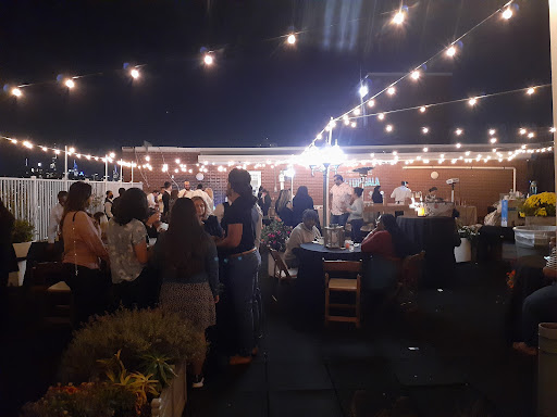 A lively outdoor party illuminated by warm string lights, filled with friends enjoying the evening.