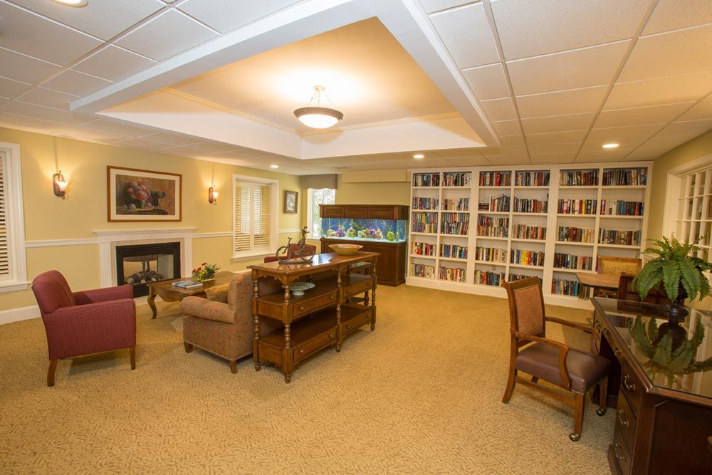 A cozy living room with bookshelves, an aquarium, and comfortable seating.