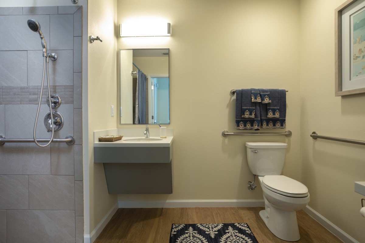 A modern bathroom with a sink, mirror, and toilet.