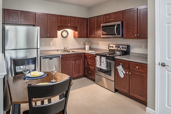 A modern kitchen with stainless steel appliances and wooden cabinetry.