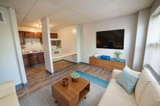 A modern open-concept living area featuring a cozy seating arrangement and a well-equipped kitchen.