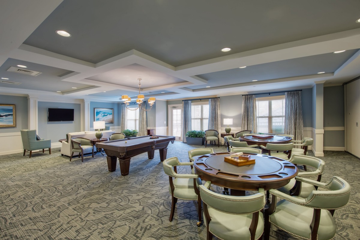 A modern lounge area featuring a pool table and comfortable seating.